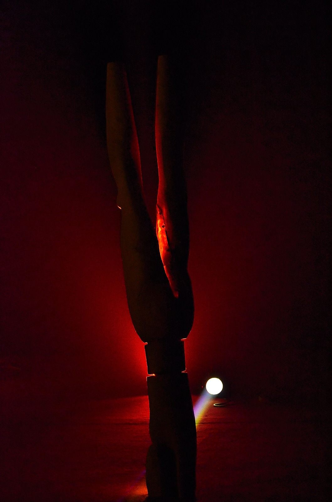 Le totem Back to the Earth en contre-jour, baigné d'une lumière rouge comme une braise.